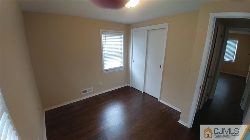 1019 Main Street Fords, NJ 08863 - Photo 7 of 13 an empty room with wooden floor and windows