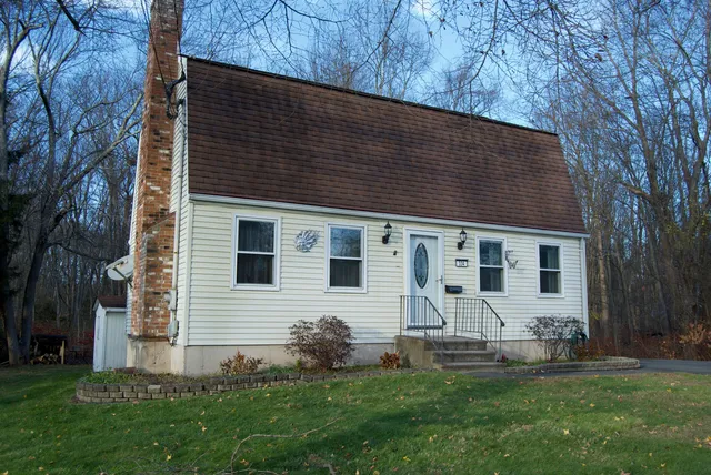 a backyard of a house with table and chairs