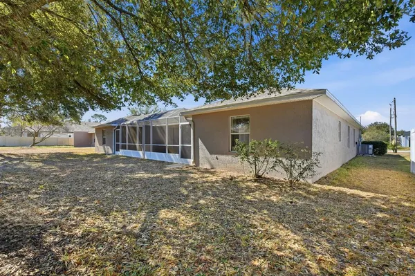 a view of a house with a yard and large tree