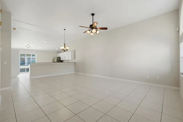 an empty room with windows and ceiling fan