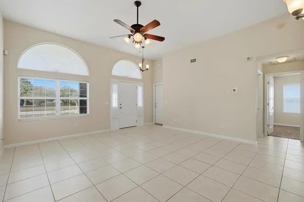 a view of a kitchen with white cabinets and chandelier