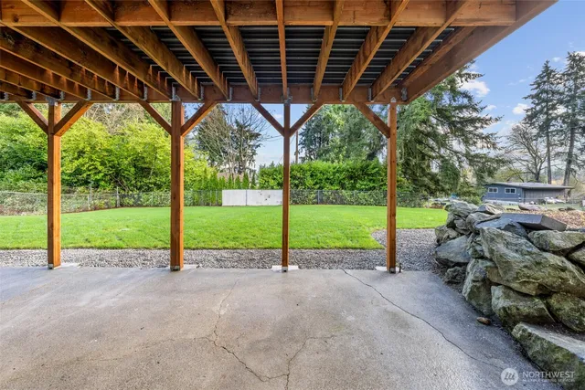 a view of a backyard with floor to ceiling windows and wooden fence