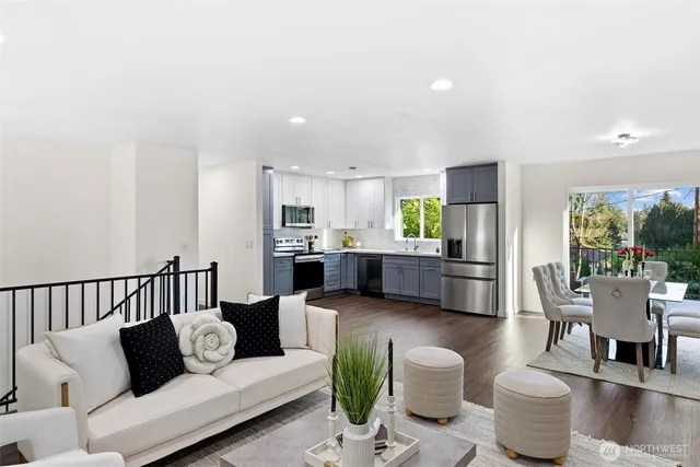 a living room with furniture kitchen view and a large window