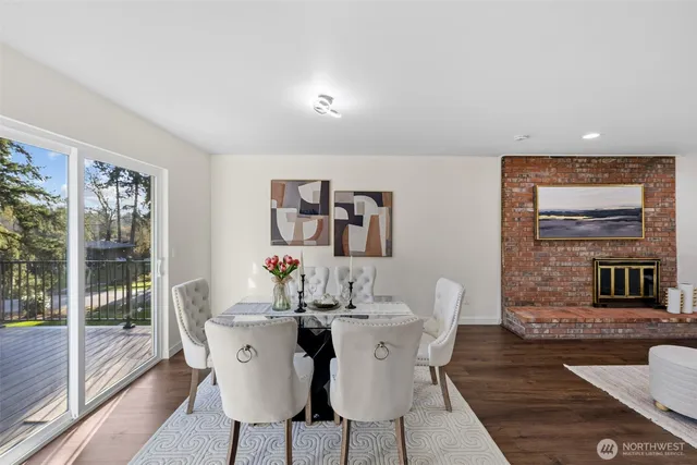 a dining room with furniture a floor to ceiling window and wooden floor