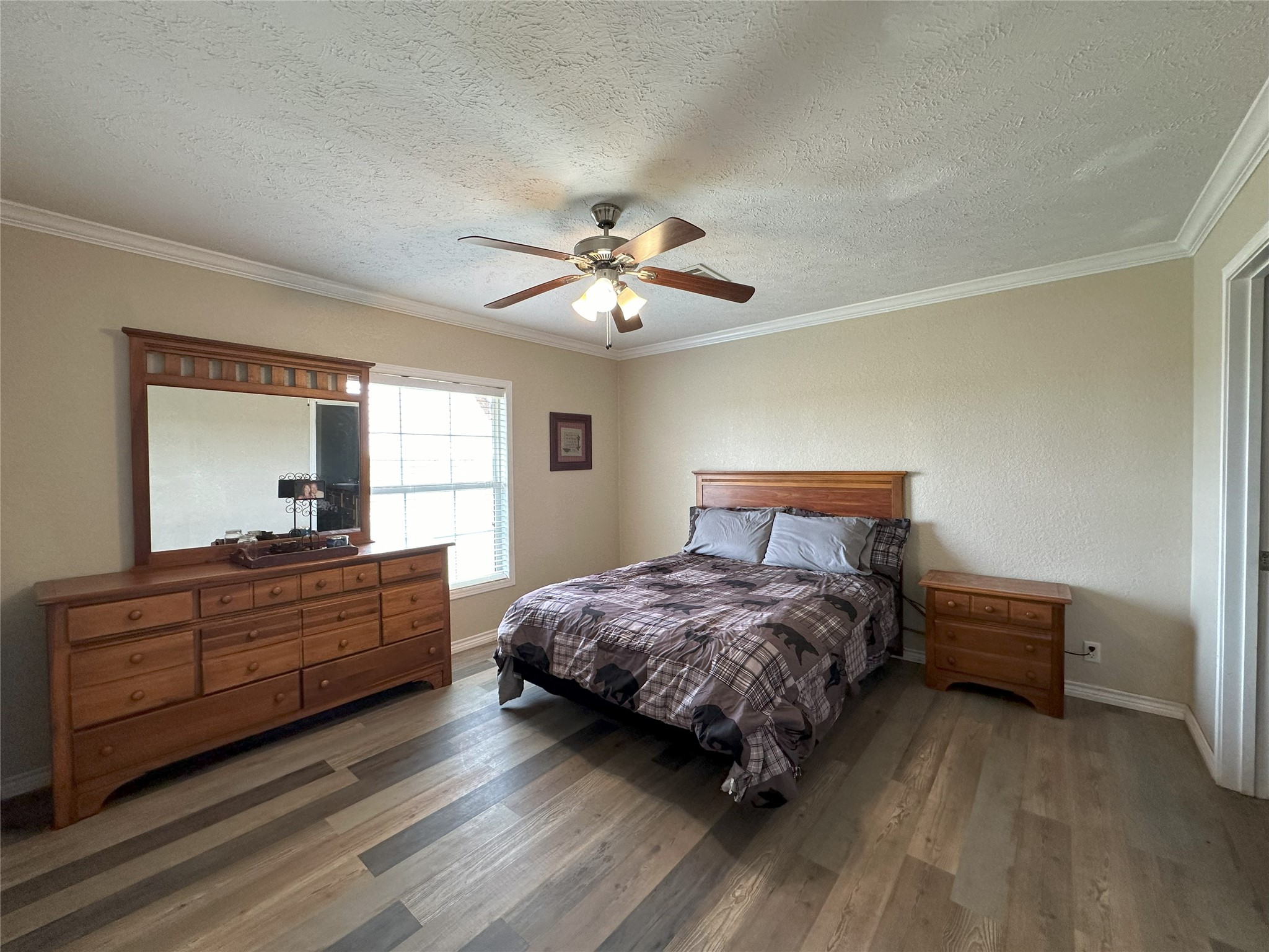 906 C R 235 Old Glory, TX 79540 - Photo 26 of 40 Bedroom with wood finished floors, a textured ceiling, ornamental molding, baseboards, and ceiling fan