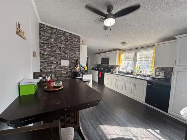 a kitchen with a table chairs and white appliances