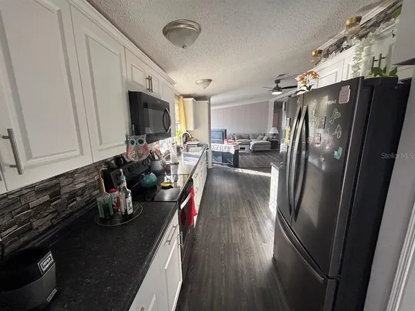a kitchen with a refrigerator and a stove top oven