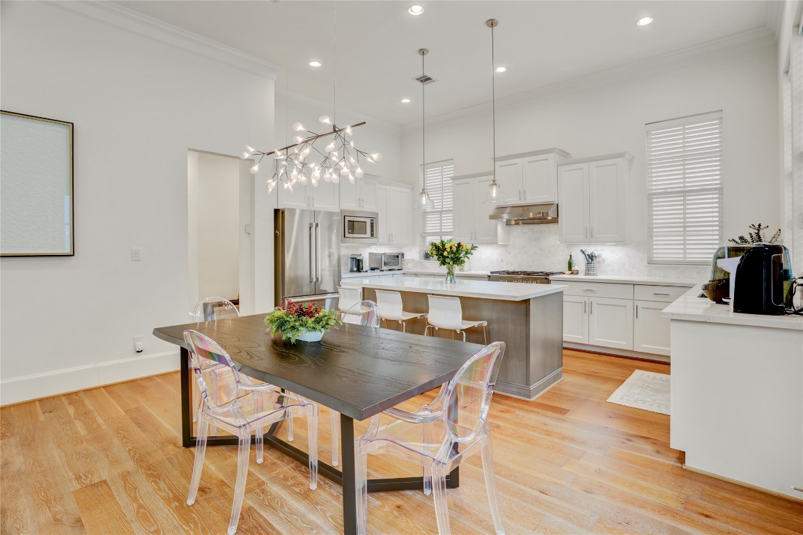 630 Delmar Street Houston, TX 77023 - Photo 4 of 27 a kitchen with kitchen island a dining table chairs and white cabinets
