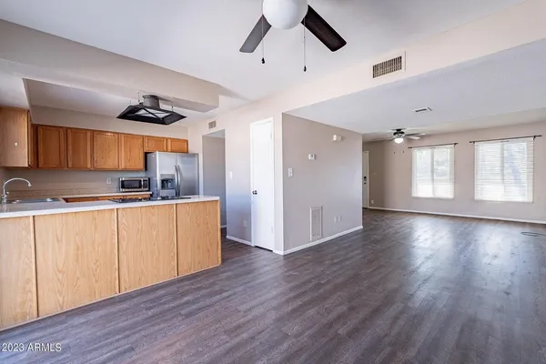 a kitchen with hard wood floors and white stainless steel appliances