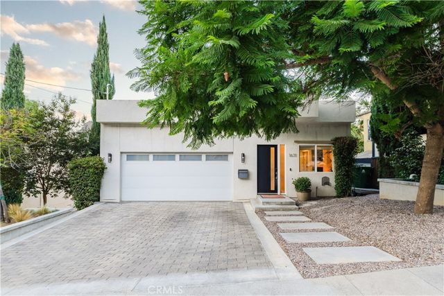 front view of a house with a yard and a trees