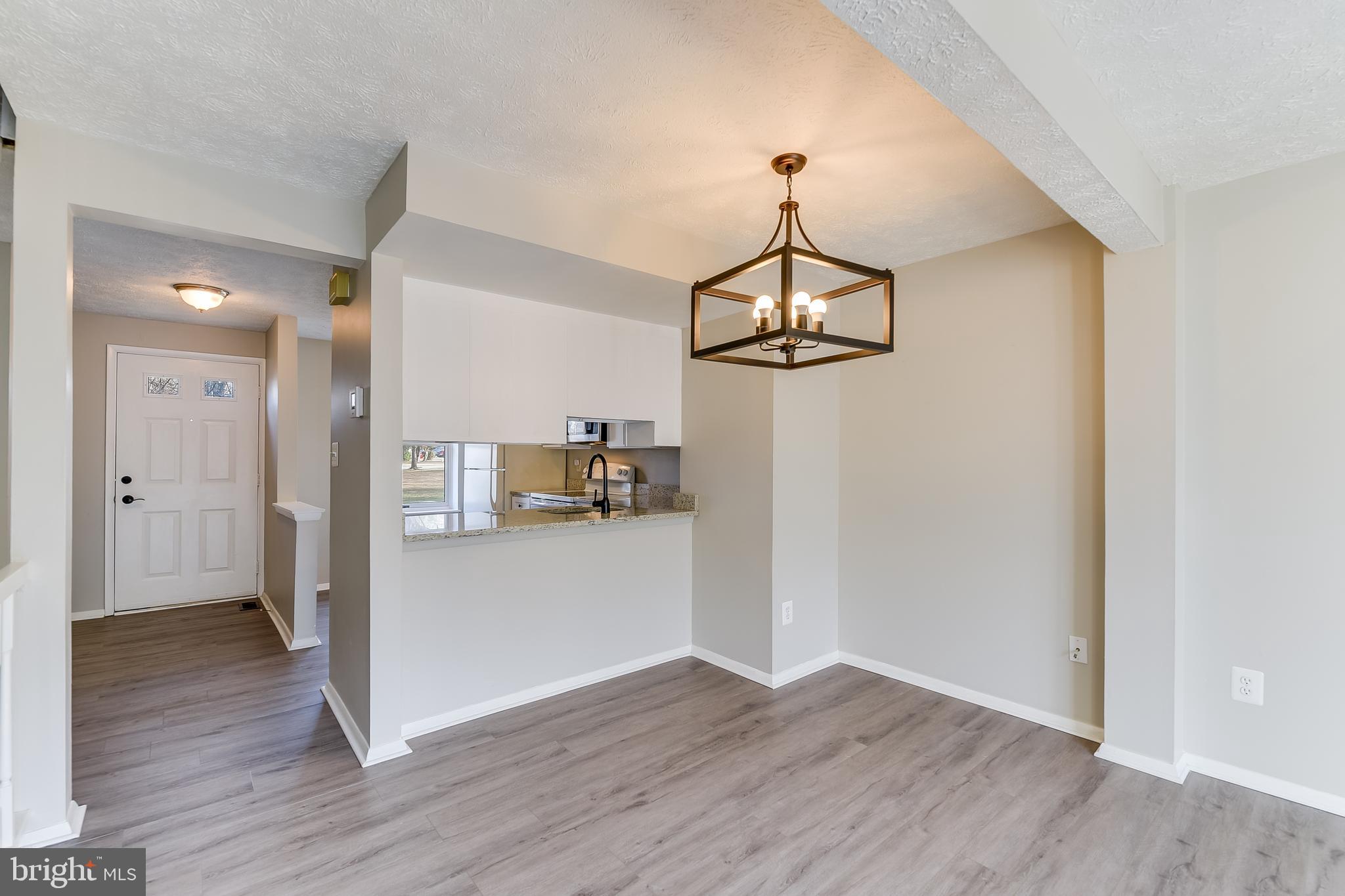 7946 Sutherland Court Pasadena, MD 21122 - Photo 14 of 37 a view of a room with wooden floor and a kitchen