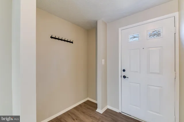 a view of a small space with wooden floor and a window
