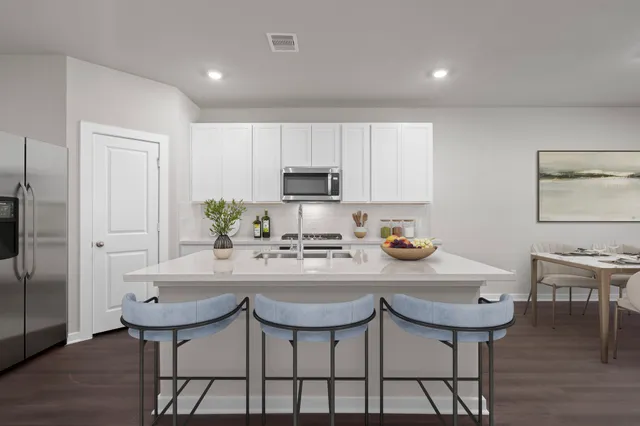 a kitchen with stainless steel appliances granite countertop a table and chairs in it
