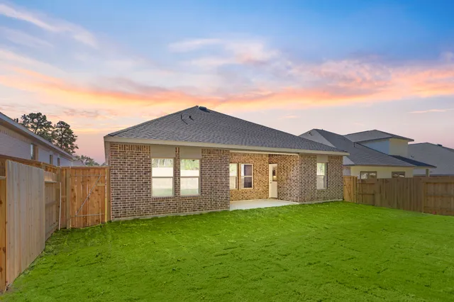a front view of a house with a garden and yard