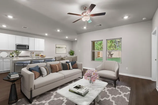 a living room with furniture kitchen and a window