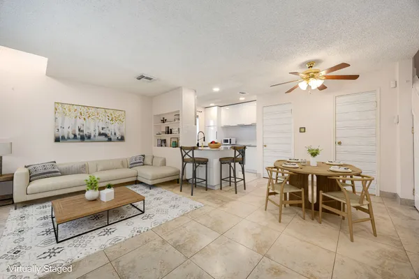 a living room with furniture a chandelier and a dining table