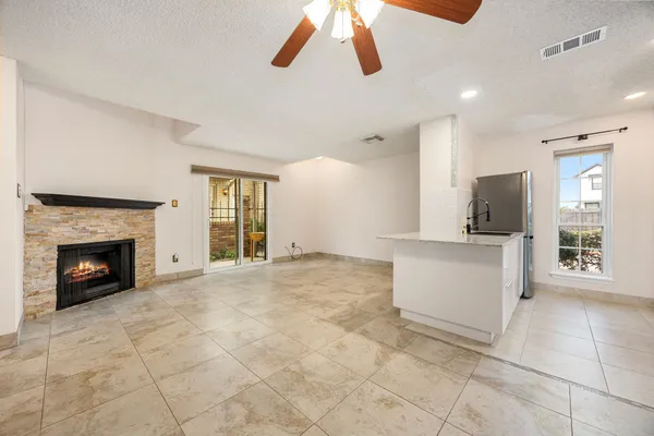a view of an empty room with a fireplace and window