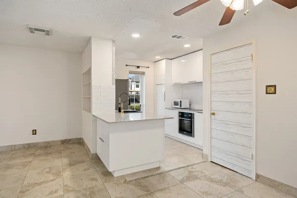 a kitchen with stainless steel appliances kitchen island granite countertop a stove and a refrigerator