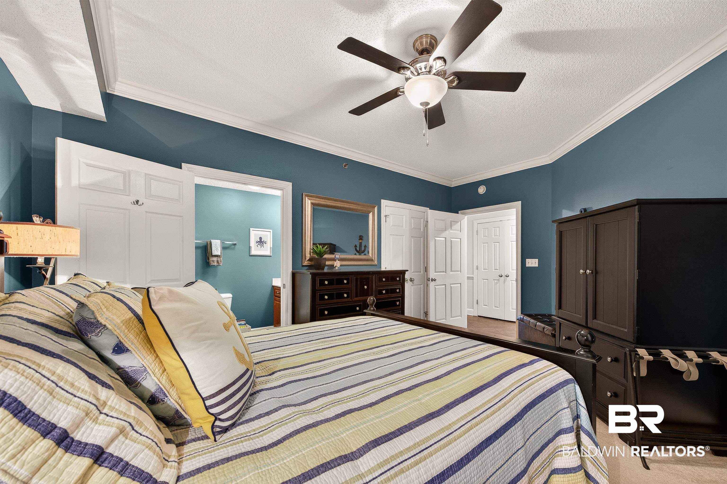 27582 Canal Road, Unit 2507 Orange Beach, AL 36561 - Photo 46 of 75 Bedroom featuring crown molding, connected bathroom, a textured ceiling, a ceiling fan, and a closet