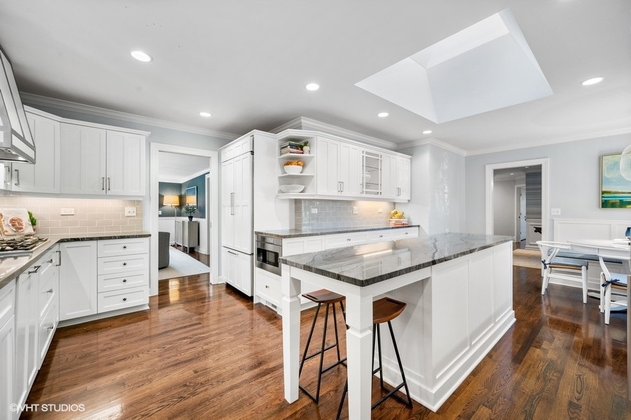 915 Golfview Road Glenview, IL 60025 - Photo 7 of 31 a kitchen with granite countertop a wooden floor and white stainless steel appliances