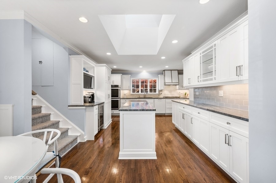 915 Golfview Road Glenview, IL 60025 - Photo 8 of 31 a kitchen with kitchen island white cabinets stainless steel appliances and center island