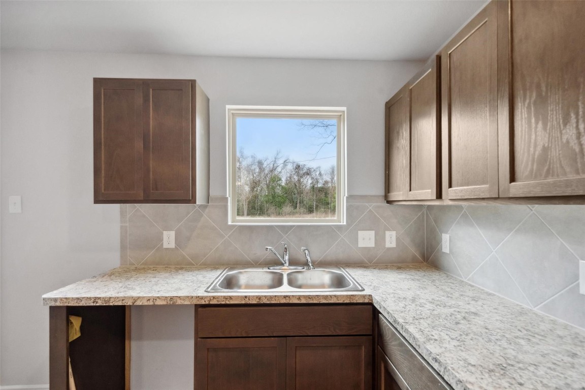515 16th Street Hempstead, TX 77445 - Photo 11 of 23 a bathroom with a granite countertop sink a mirror and cabinets