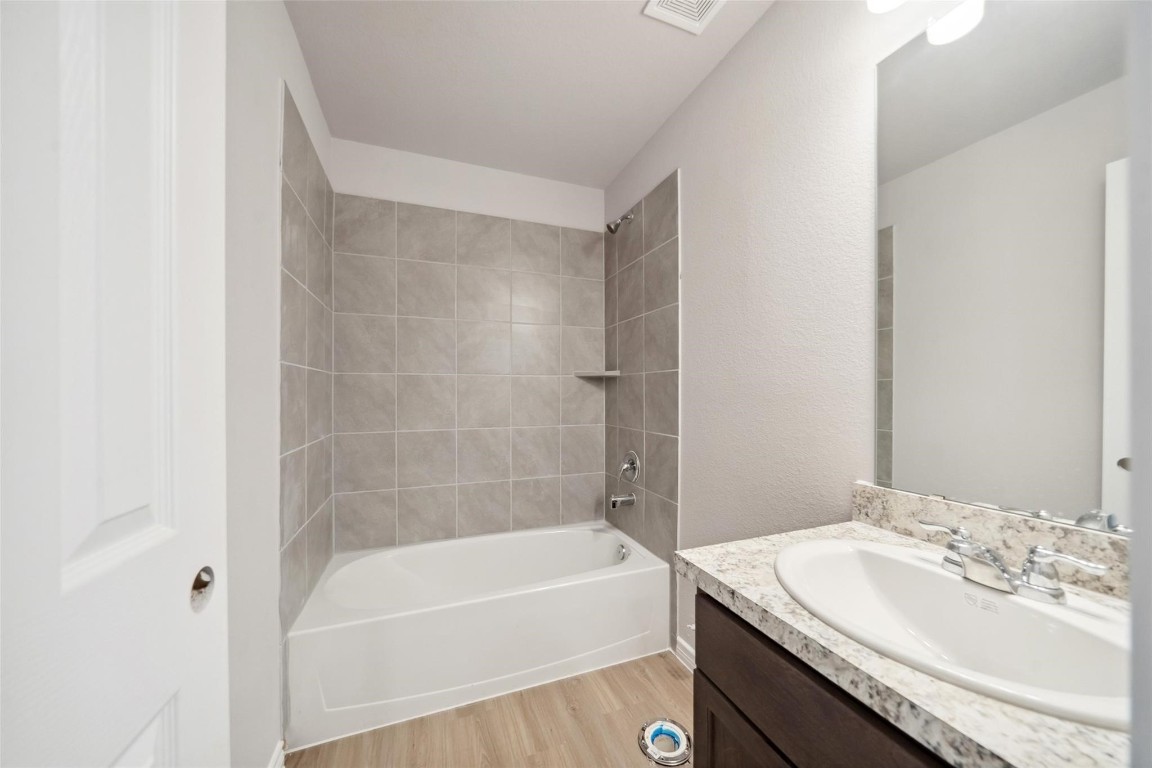 515 16th Street Hempstead, TX 77445 - Photo 18 of 23 a bathroom with a granite countertop bathtub shower sink vanity and toilet