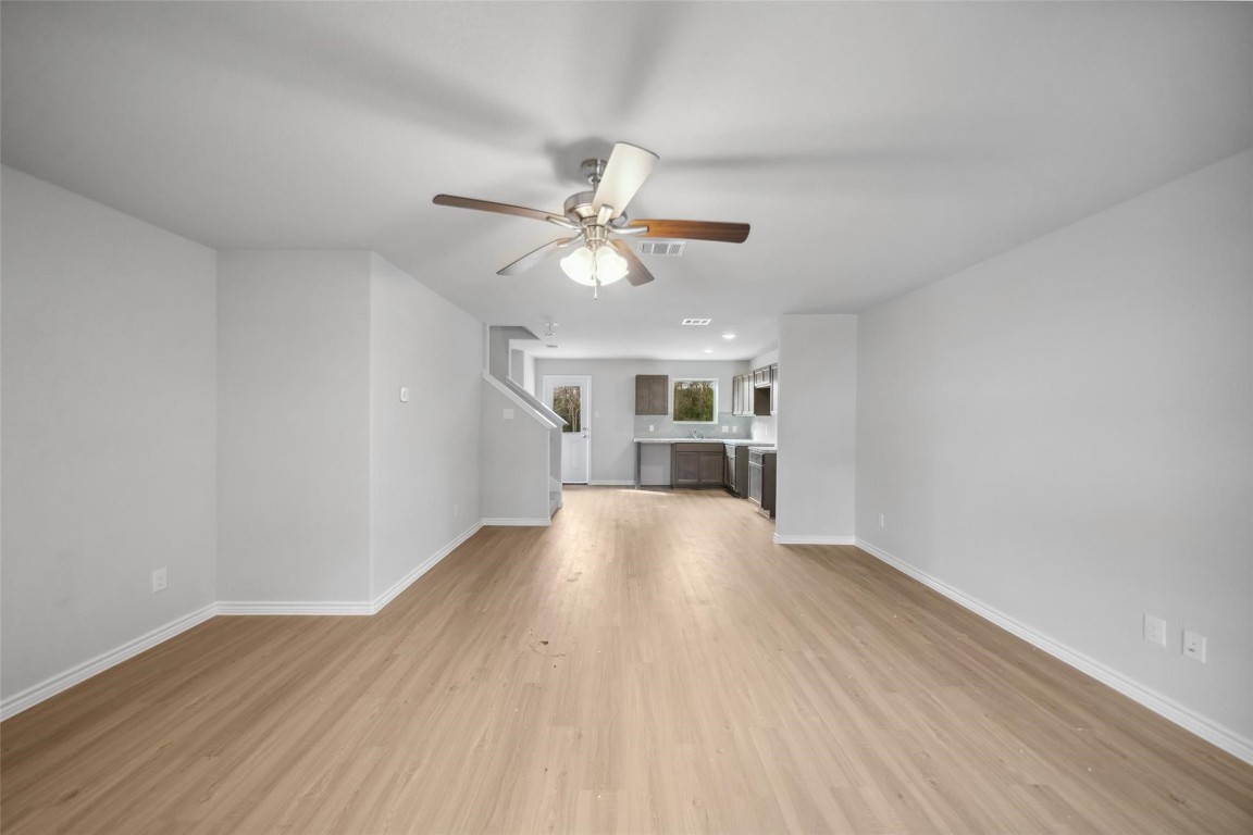 515 16th Street Hempstead, TX 77445 - Photo 5 of 23 a view of an empty room with a kitchen and wooden floor