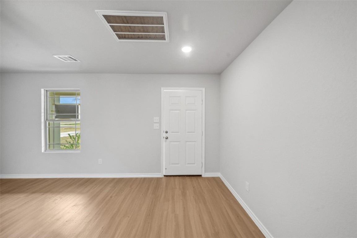 515 16th Street Hempstead, TX 77445 - Photo 6 of 23 an empty room with wooden floor and a window