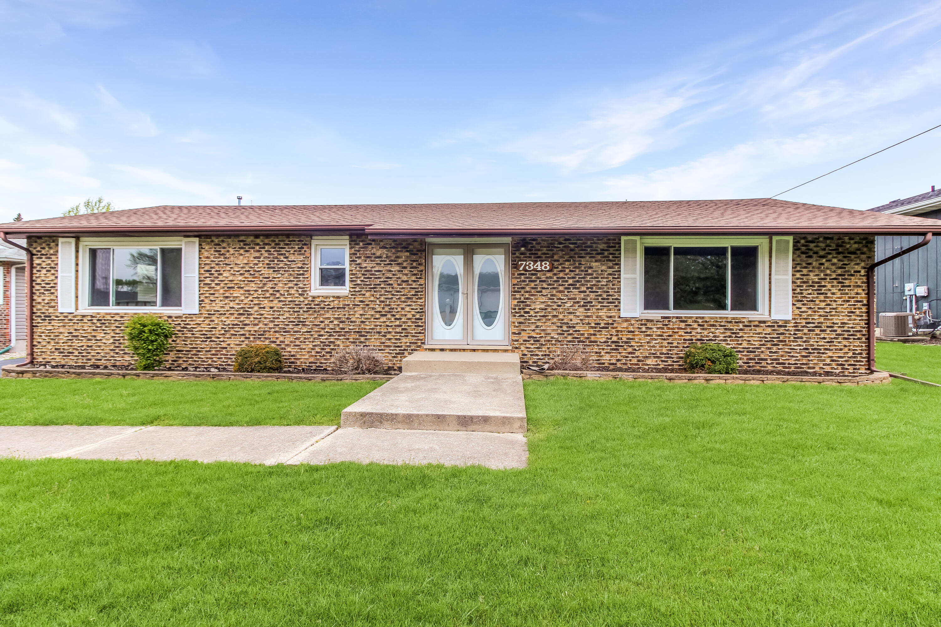 7348 West 83rd Place Crown Point, IN 46307 - Photo 1 of 14 a front view of a house with a garden