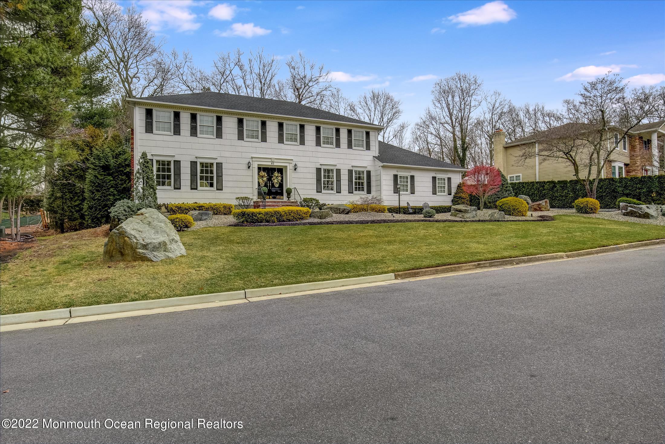 a view of a house with a big yard and large trees