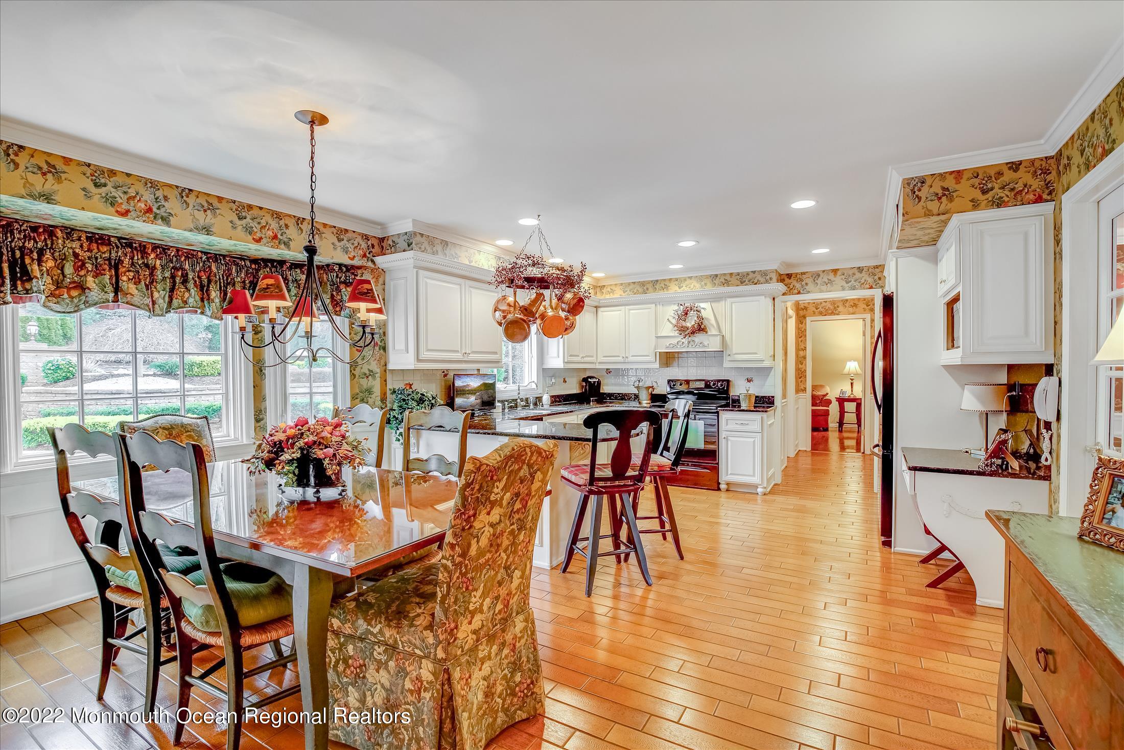45 Ruby Drive Morganville, NJ 07751 - Photo 12 of 47 a dining hall with stainless steel appliances granite countertop a table chairs and a chandelier