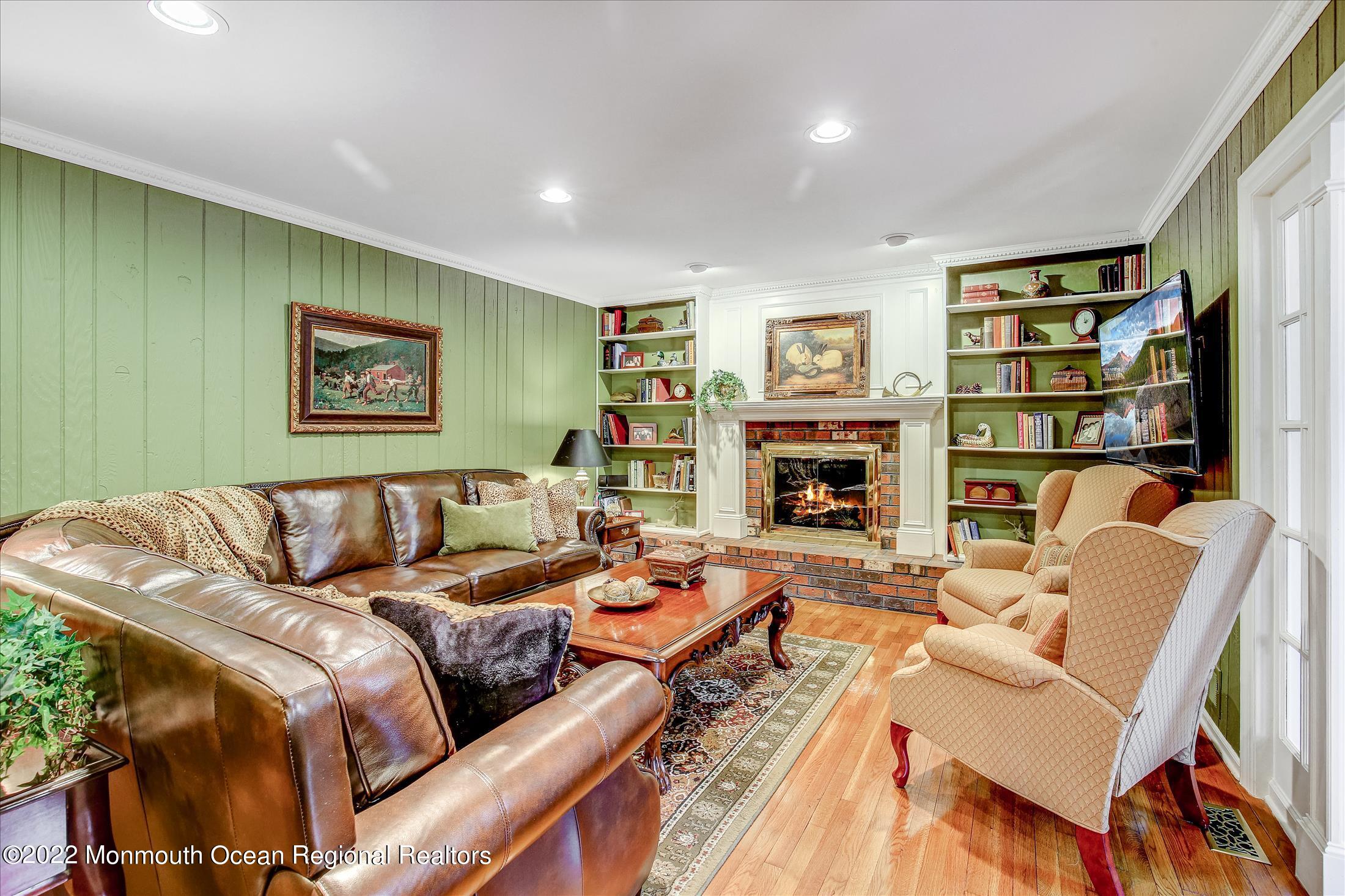 45 Ruby Drive Morganville, NJ 07751 - Photo 17 of 47 a living room with fireplace furniture and a book shelf