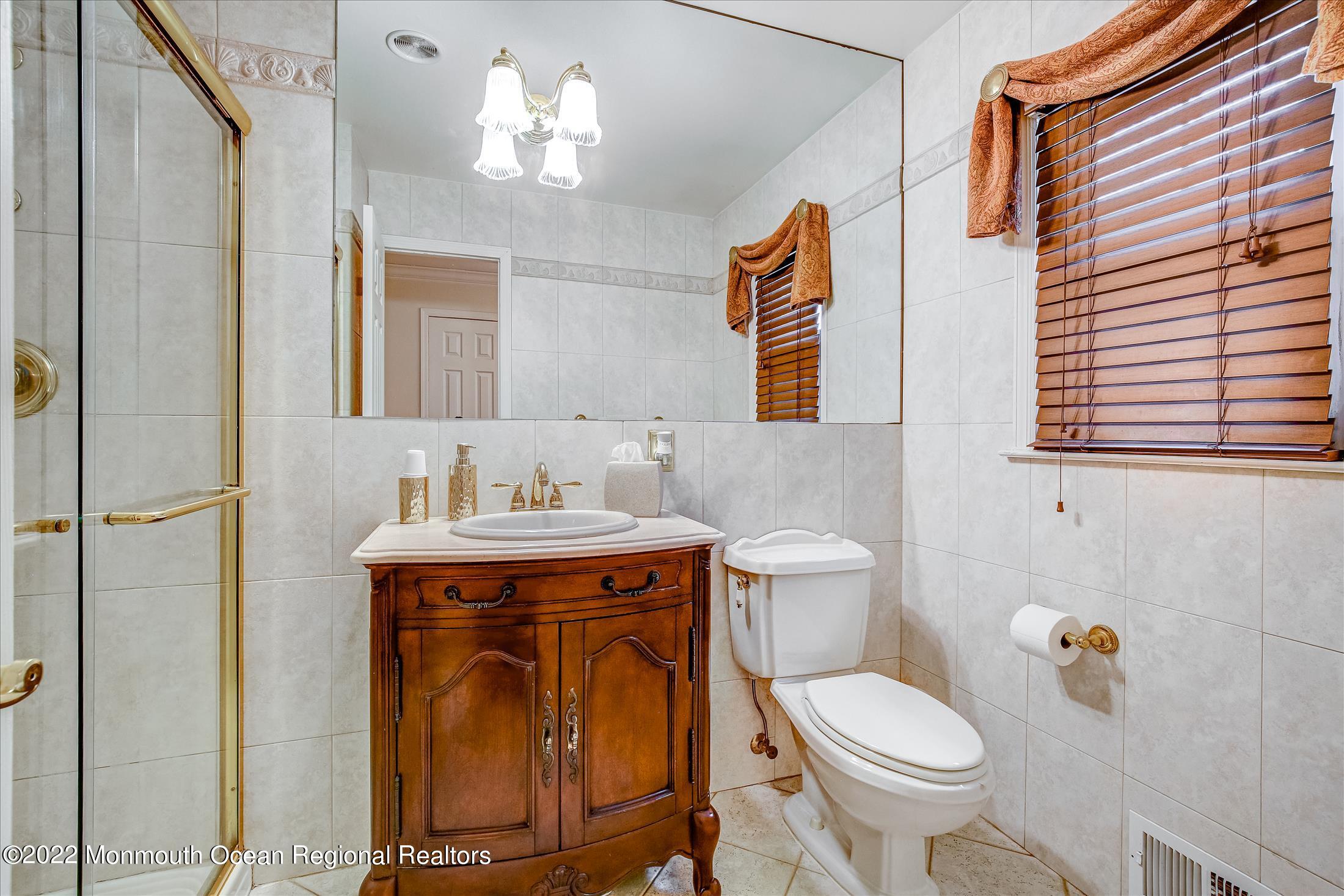 45 Ruby Drive Morganville, NJ 07751 - Photo 31 of 47 a bathroom with a sink a toilet and a mirror