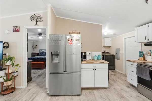 a kitchen with a refrigerator a stove top oven a counter space and wooden floor