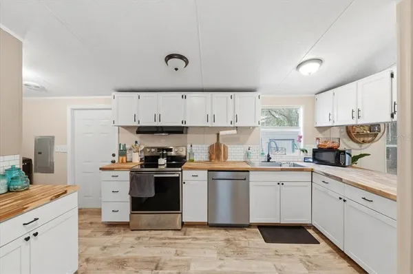 a kitchen with granite countertop appliances sink and cabinets
