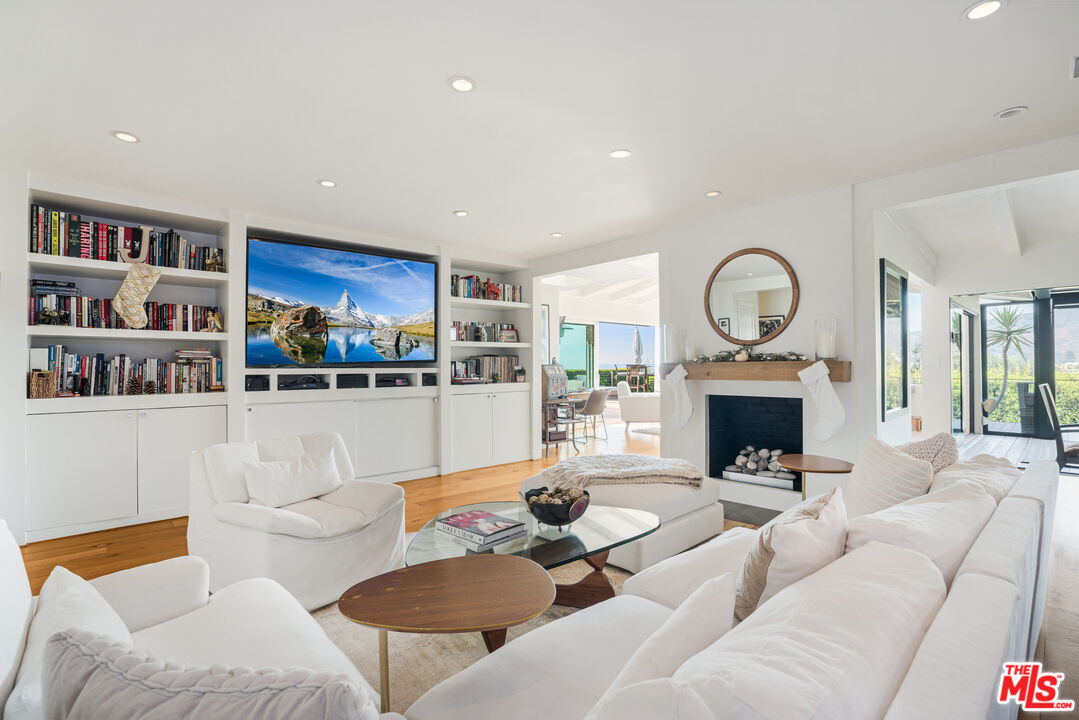 245 Tranquillo Road Pacific Palisades, CA 90272 - Photo 13 of 45 a living room with furniture a rug and a fireplace