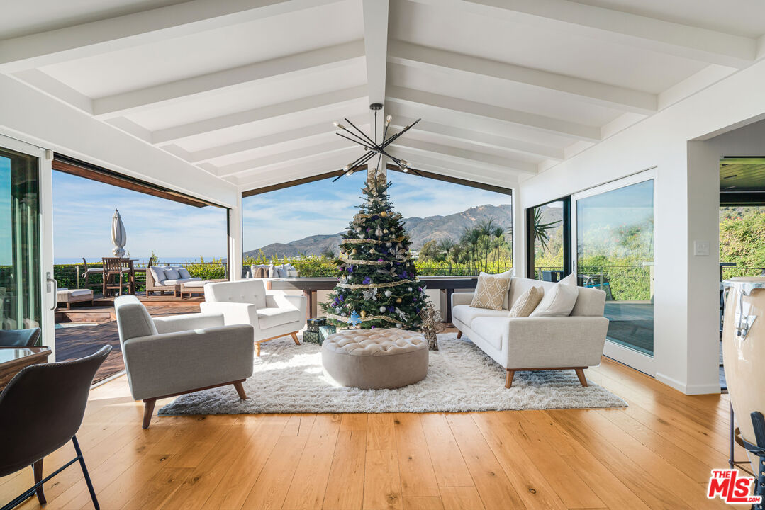 245 Tranquillo Road Pacific Palisades, CA 90272 - Photo 14 of 45 a living room with fireplace furniture and a large window