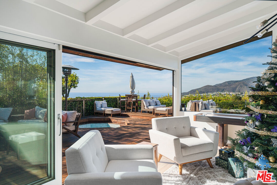 245 Tranquillo Road Pacific Palisades, CA 90272 - Photo 15 of 45 a living room with patio furniture and a floor to ceiling window