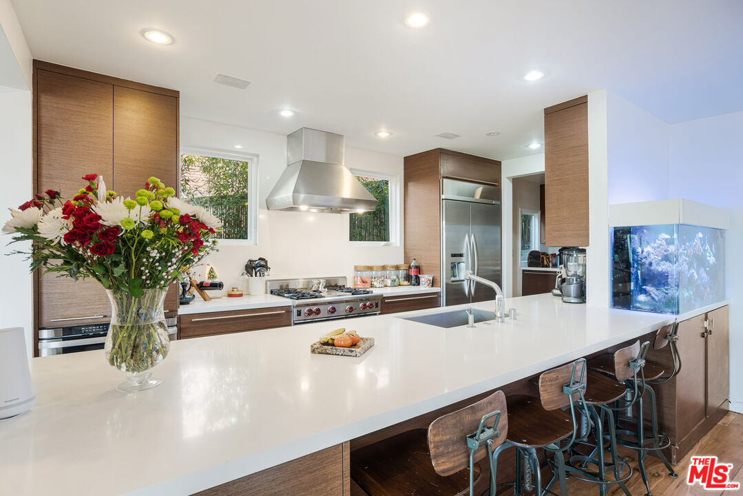 245 Tranquillo Road Pacific Palisades, CA 90272 - Photo 20 of 45 a view of a kitchen with kitchen island a sink and a refrigerator