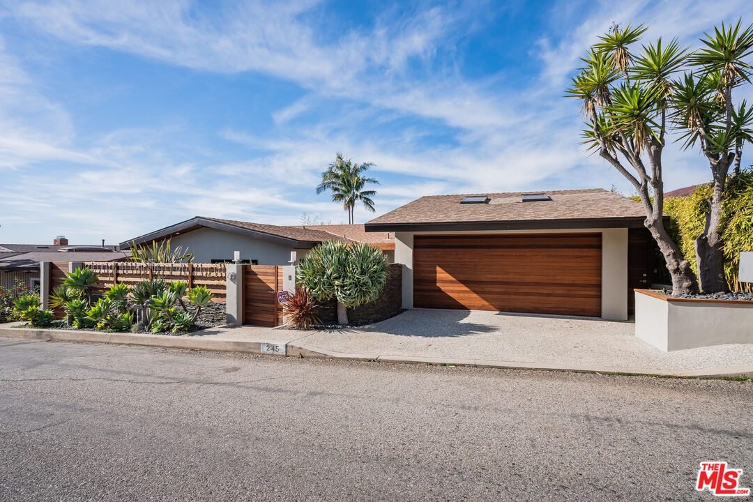 245 Tranquillo Road Pacific Palisades, CA 90272 - Photo 2 of 45 a front view of a house with a yard and garage