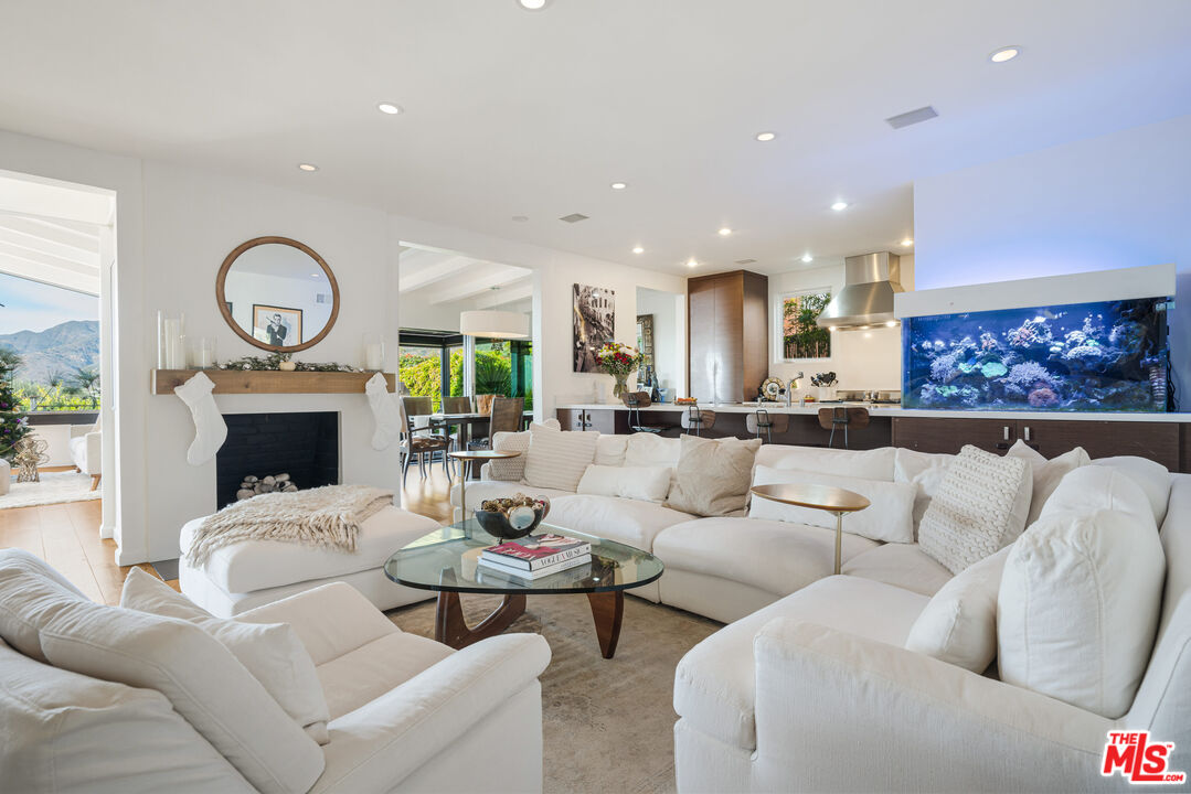 245 Tranquillo Road Pacific Palisades, CA 90272 - Photo 9 of 45 a living room with furniture a fireplace and a large window