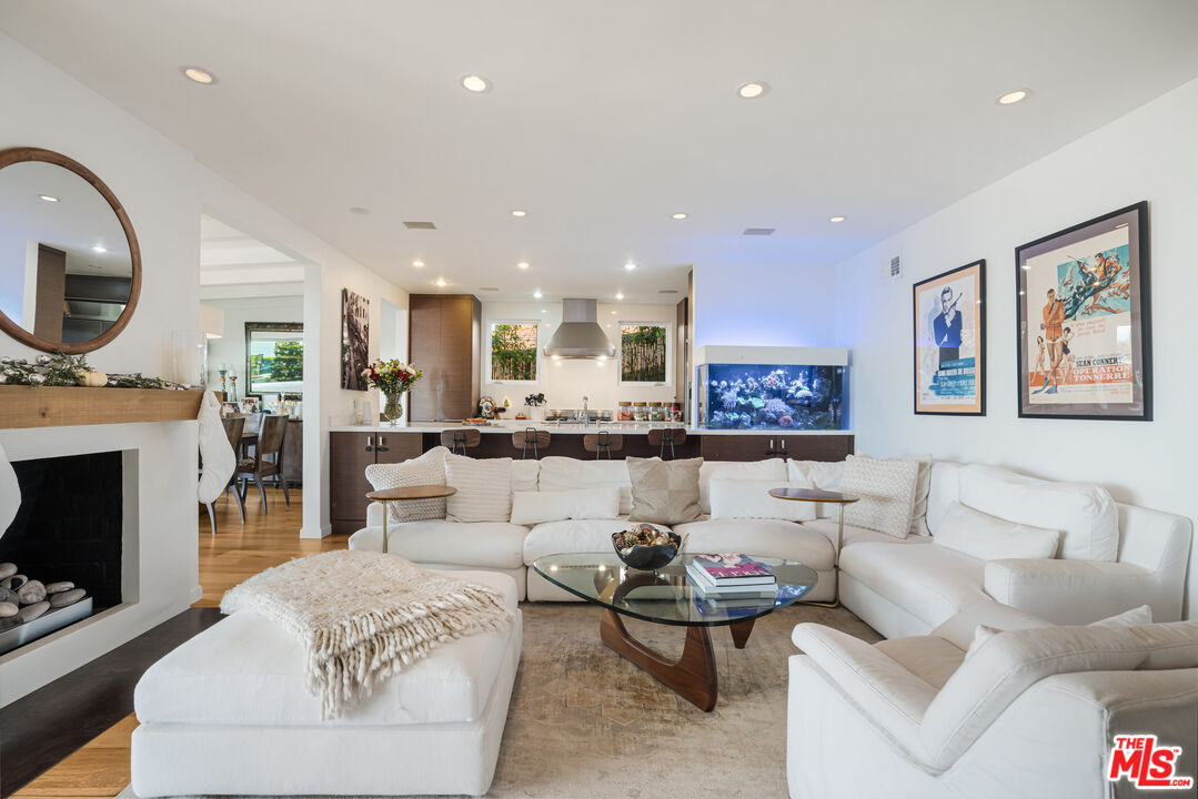 245 Tranquillo Road Pacific Palisades, CA 90272 - Photo 10 of 45 a living room with furniture a fireplace and a flat screen tv