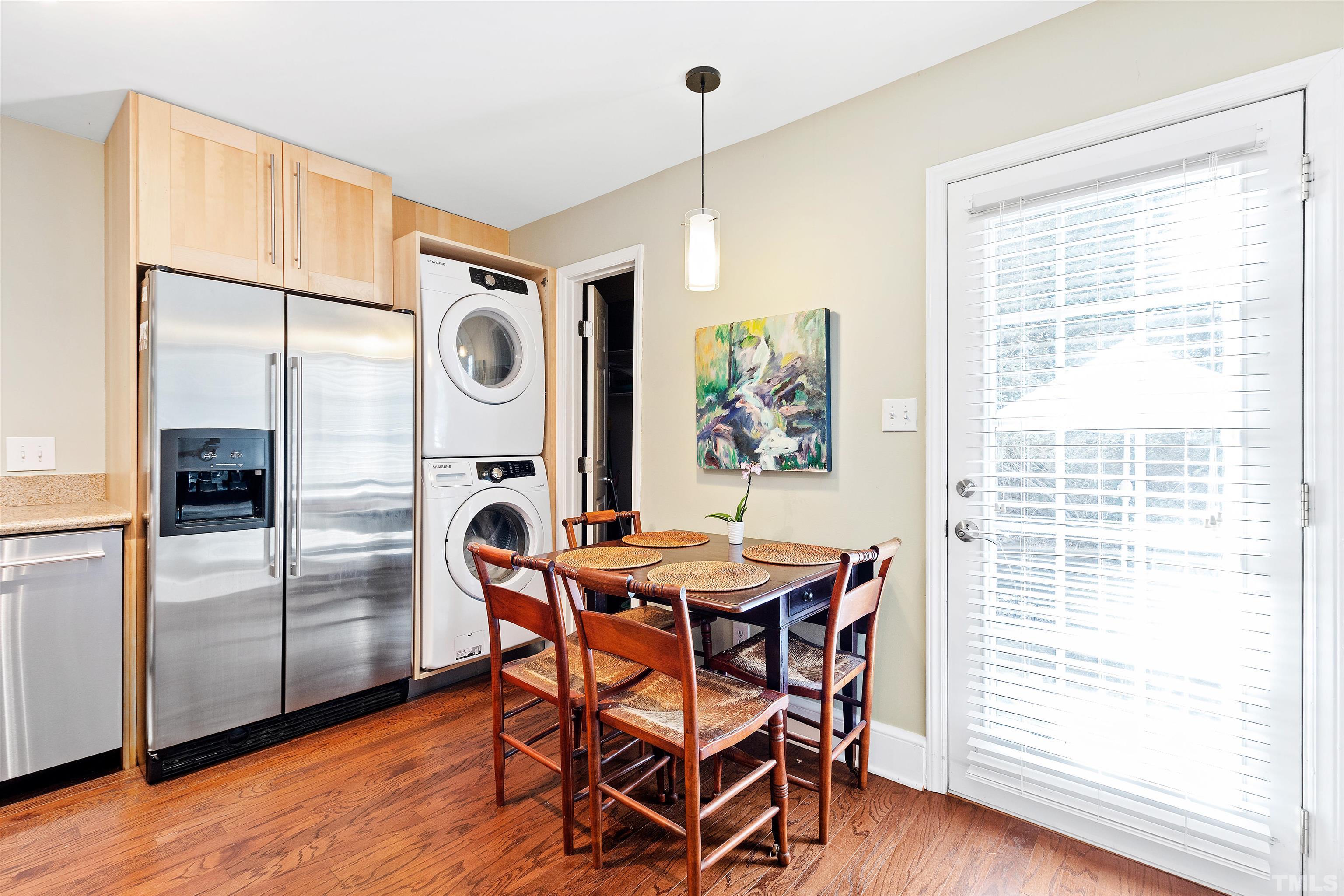 2526 Noble Road Raleigh, NC 27608 - Photo 12 of 27 a kitchen with stainless steel appliances granite countertop a table chairs and a refrigerator