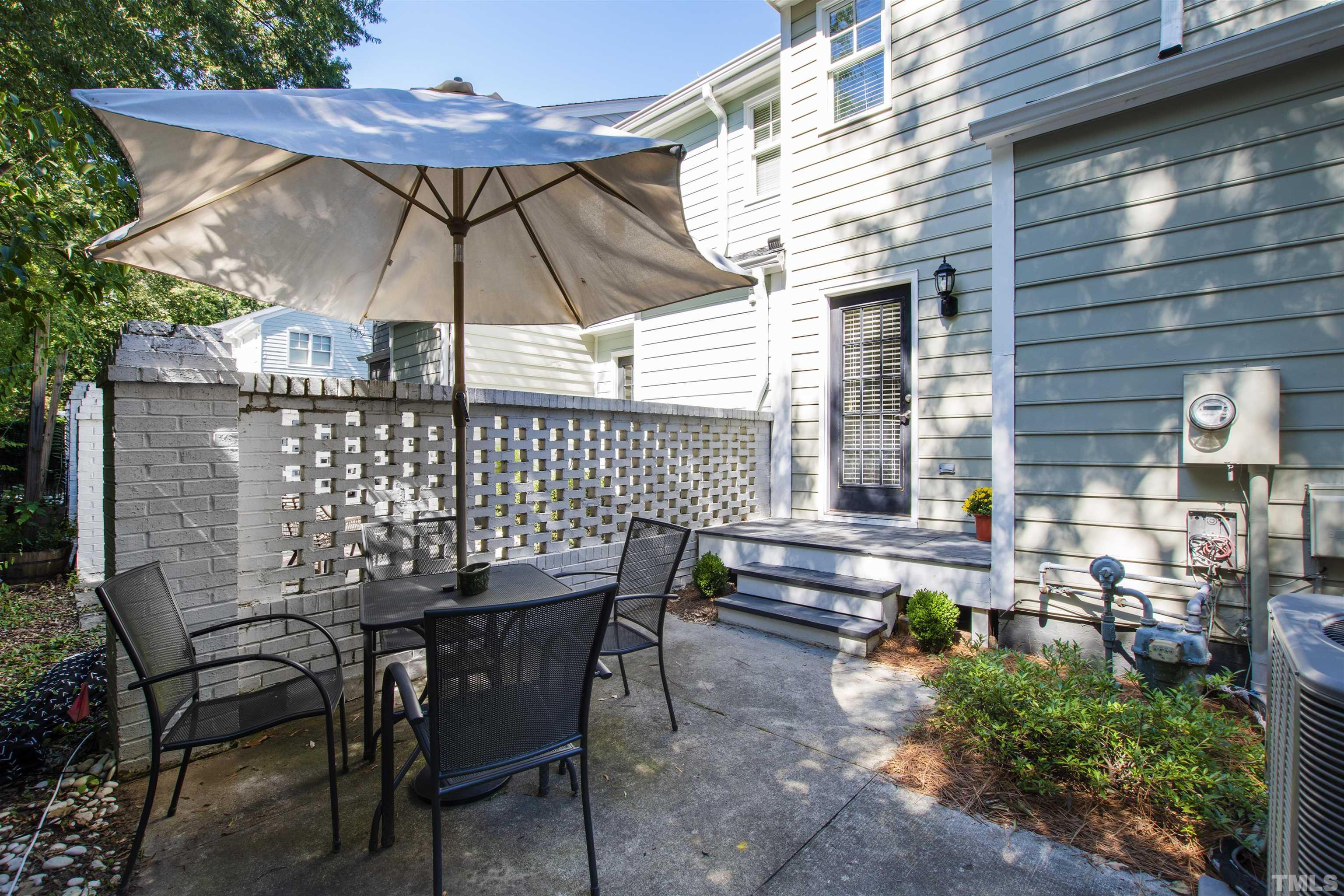2526 Noble Road Raleigh, NC 27608 - Photo 23 of 27 a patio with a table and chairs under an umbrella