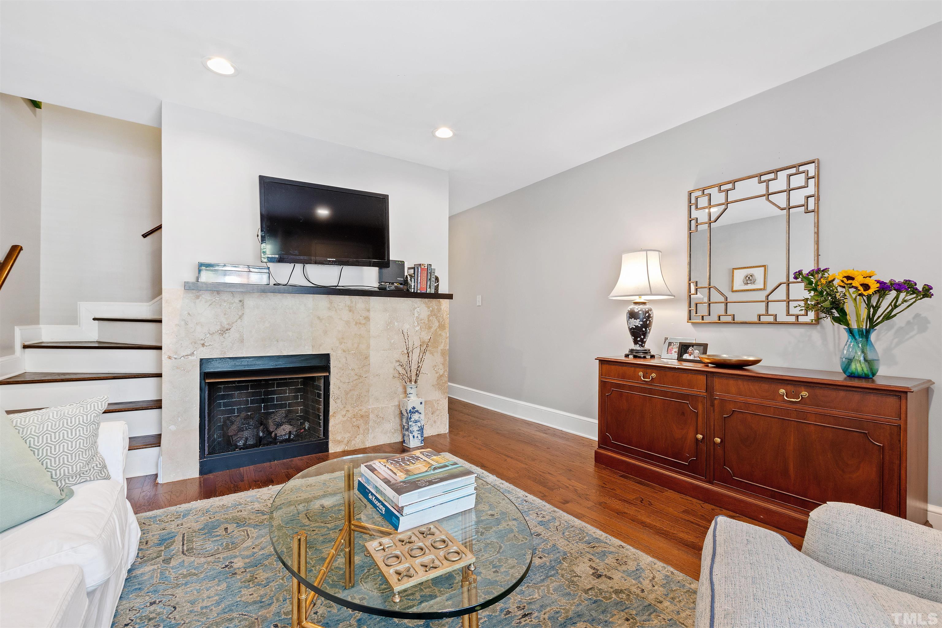 2526 Noble Road Raleigh, NC 27608 - Photo 8 of 27 a living room with furniture a flat screen tv and a fireplace