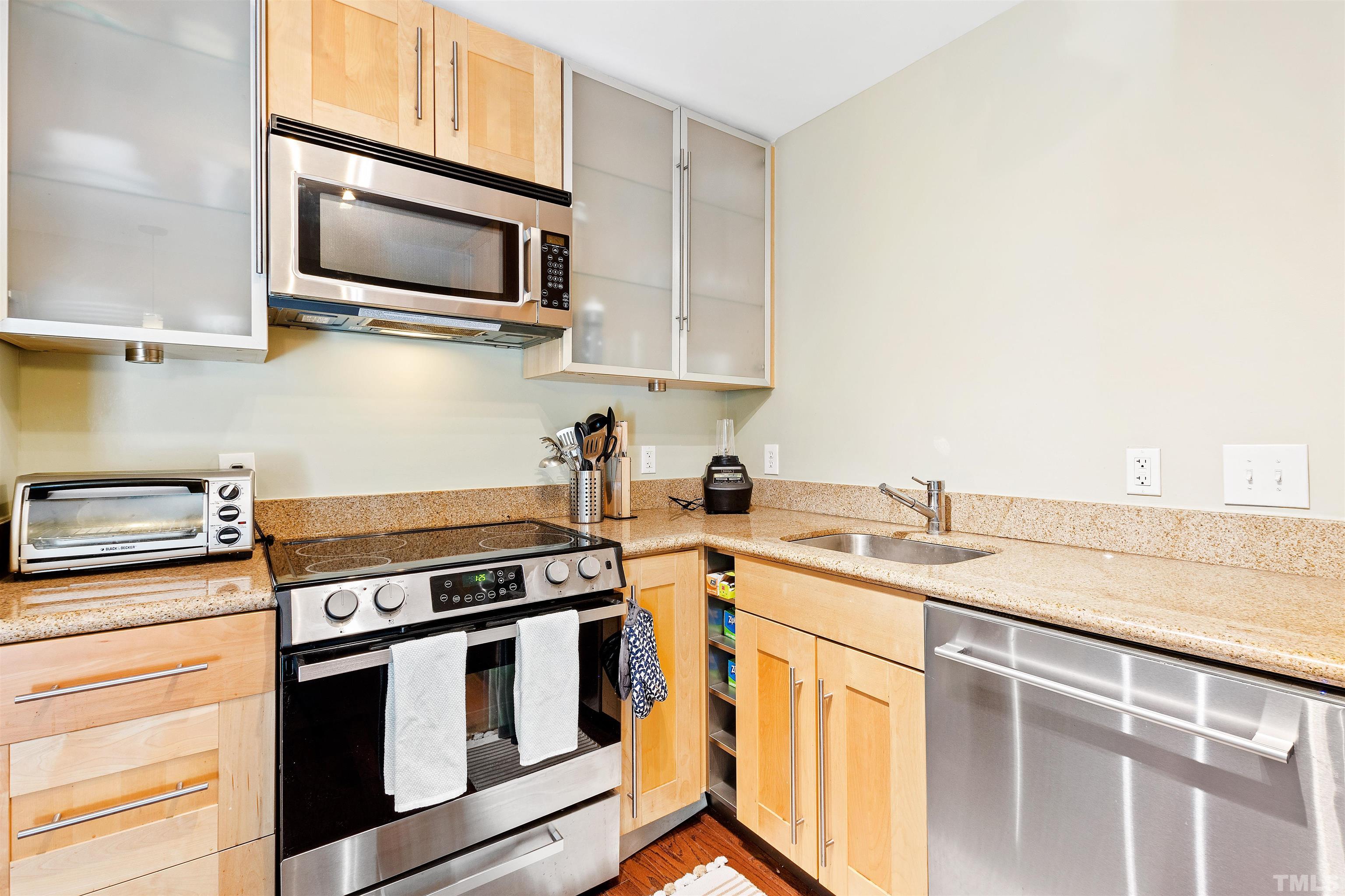 2526 Noble Road Raleigh, NC 27608 - Photo 10 of 27 a kitchen with stainless steel appliances granite countertop a sink stove microwave and refrigerator