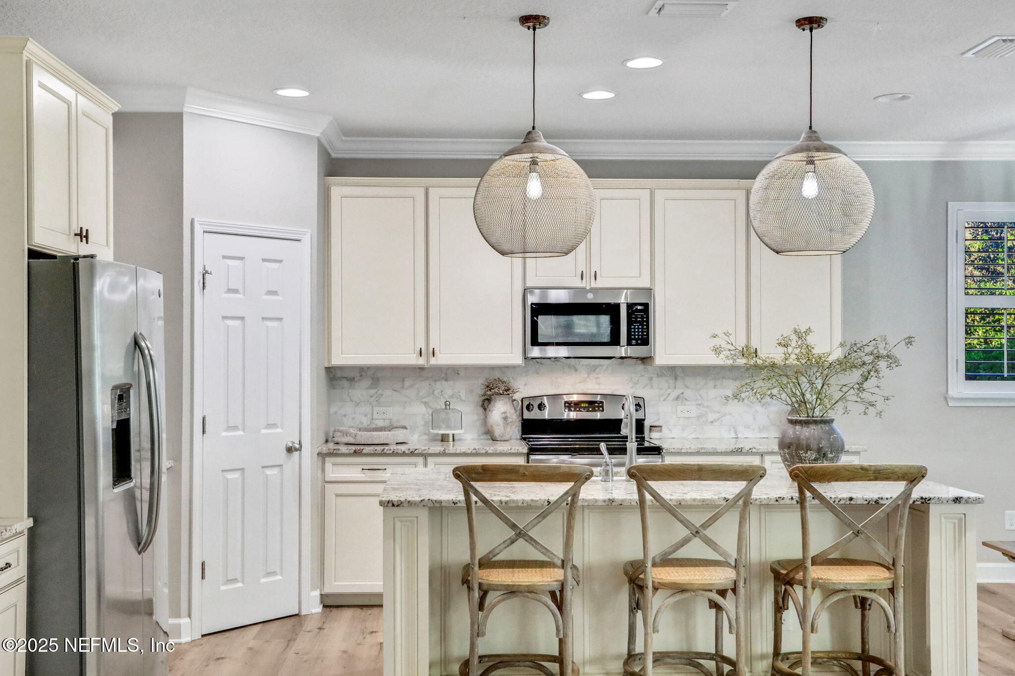 119 Duck Pond Drive St. Augustine, FL 32086 - Photo 11 of 56 a kitchen with stainless steel appliances kitchen island granite countertop a refrigerator a stove a microwave oven a sink with a dining table and chairs