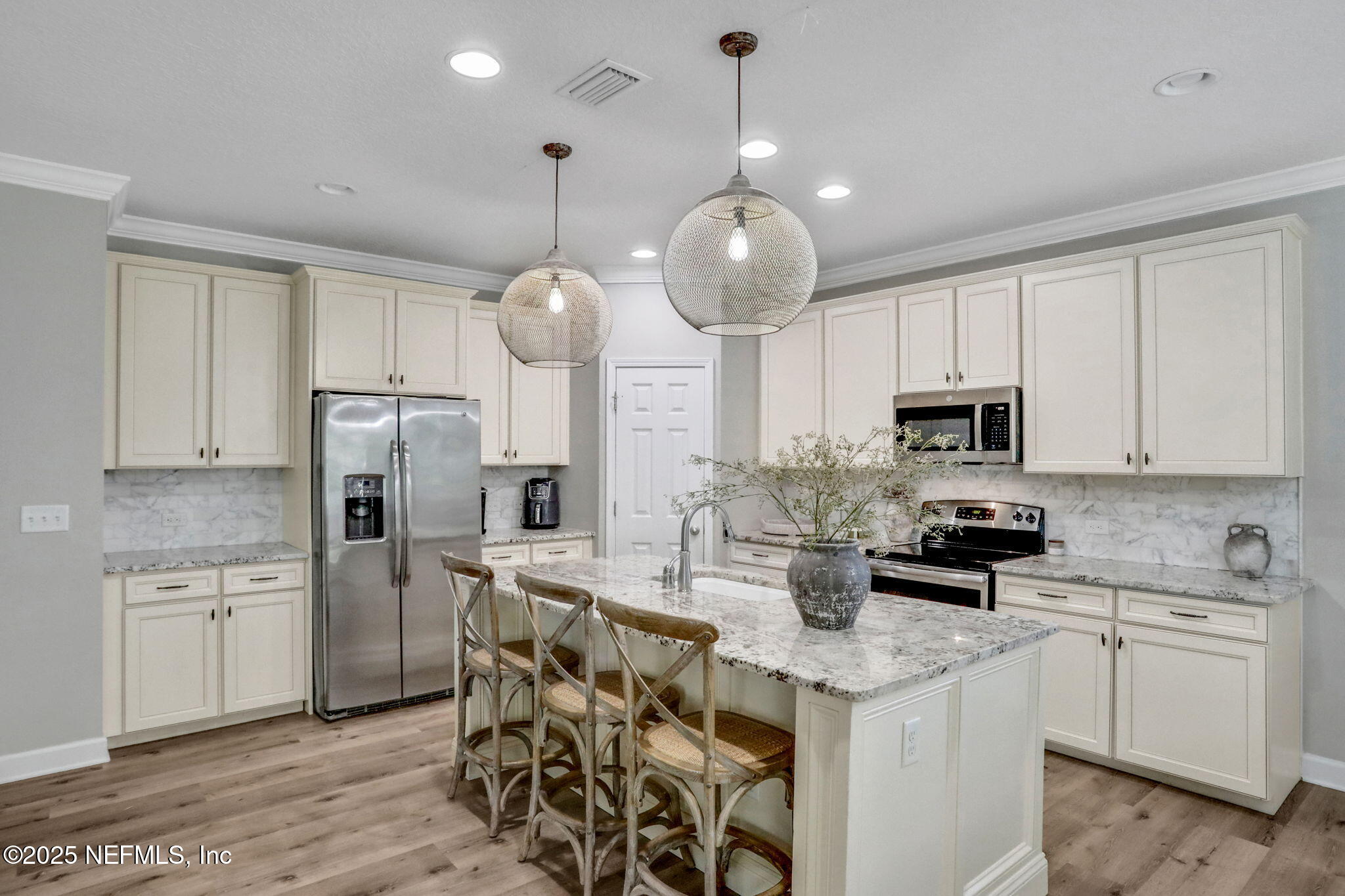 119 Duck Pond Drive St. Augustine, FL 32086 - Photo 12 of 56 a kitchen with stainless steel appliances kitchen island granite countertop a refrigerator a sink dishwasher a stove and white cabinets with wooden floor