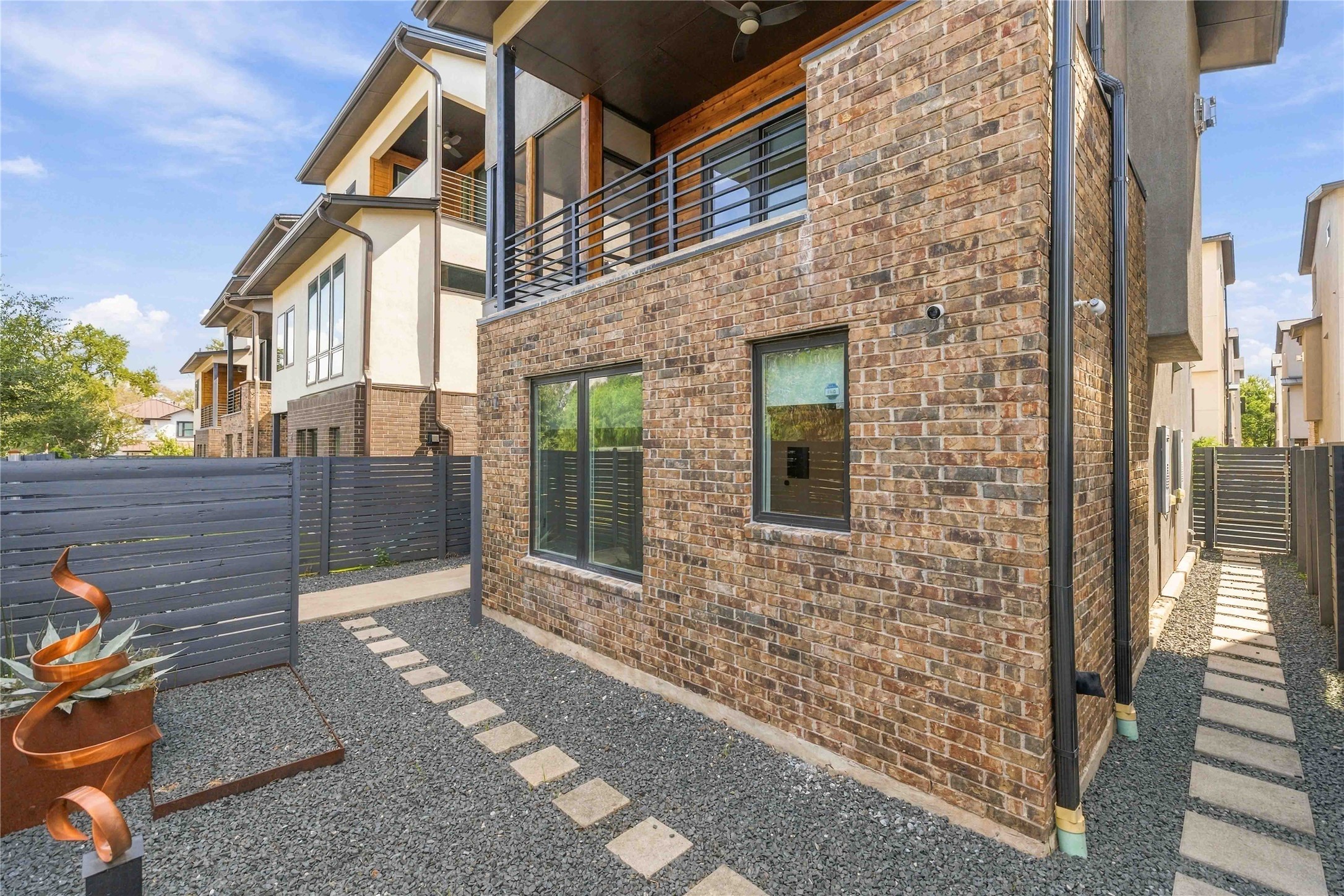 5006 Pecan Springs Road, Unit 7 Austin, TX 78723 - Photo 34 of 38 A textured brick exterior pairs with modern black-trimmed windows and paved stone walkways.